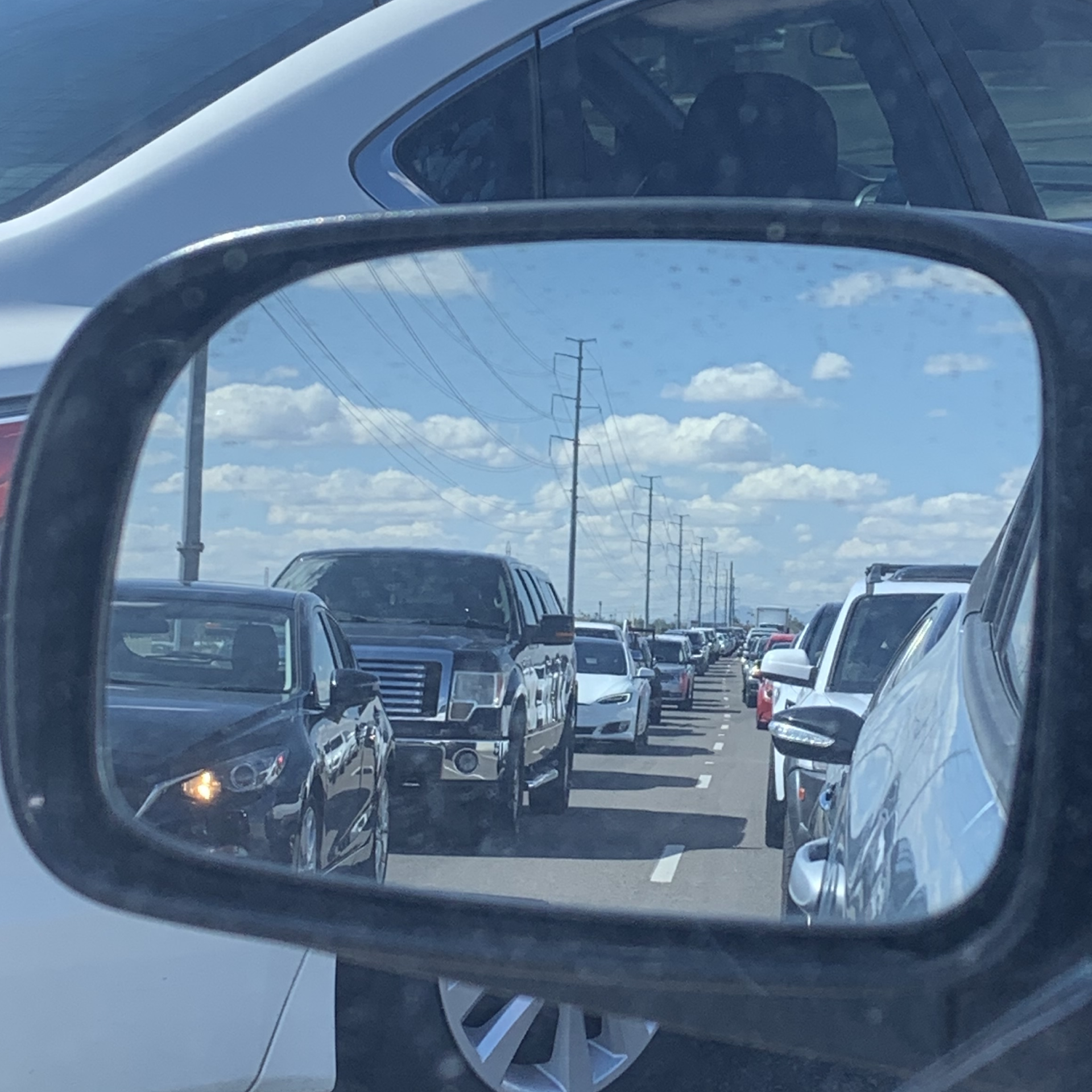 A picture from the inside of a car looking at the world through a mirror.